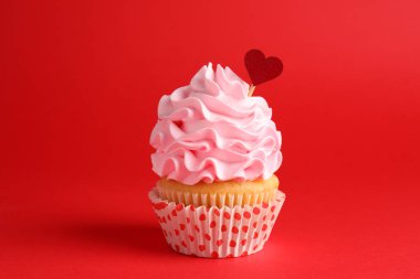 Sevgililer Günün kutlu olsun. Kırmızı arka planda kalp kaplaması olan lezzetli kek, yakın plan.