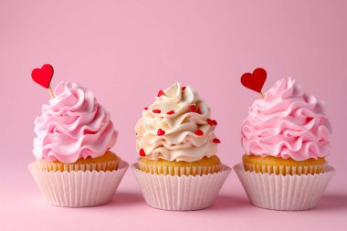 Sevgililer Günün kutlu olsun. Pembe arka planda kırmızı kalp kaplamalı lezzetli kekler, yakın plan.