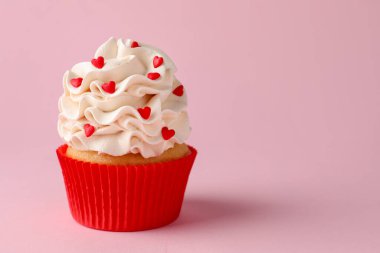 Sevgililer Günün kutlu olsun. Pembe arka planda kırmızı kalpleri olan lezzetli kek, yakın plan. Metin için boşluk