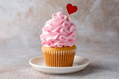 Sevgililer Günün kutlu olsun. Gri masadaki kırmızı kalpli tatlı kek, yakın plan.