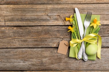 Paskalya sofrası. Güzel gümüş çatal bıçak dekoru ve ahşap arka planda boyanmış yumurta, üst manzara. Metin için boşluk