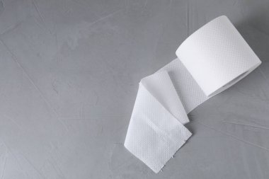 Gri masadaki tuvalet kağıdı rulosu, üst manzara. Metin için boşluk
