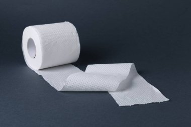 Gri arkaplanda tuvalet kağıdı rulosu, yakın plan.