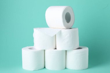 Turkuaz arka planda tuvalet kağıdı ruloları