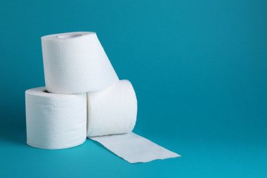 Açık mavi arkaplanda tuvalet kağıdı ruloları, metin için boşluk
