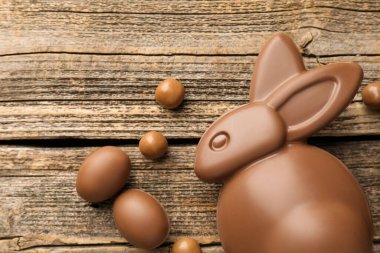 Çikolatalı Paskalya tavşanı ve yumurtalar ahşap masada, düz yatıyordu. Metin için boşluk