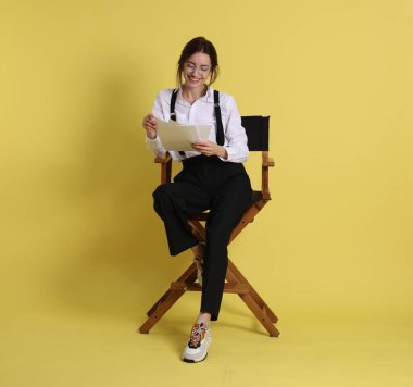 Profesyonel film yönetmeni, senaryosu sarı arka planda.