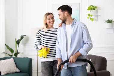 Birlikte oturma odasını toplayan bir çift. Ev işleri.