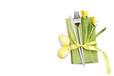 Paskalya sofrası. Nergisli güzel gümüş takımlar ve beyaza izole edilmiş yumurtalar, üst manzara.