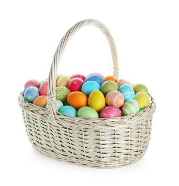 Hasır sepetteki boyanmış Paskalya yumurtaları beyaza izole edilmiş.