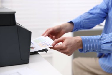 İçerideki masadaki yazıcıdan baskı kağıdı alan kadın, yakın plan.