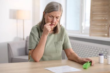 Hafıza kaybı. Hapları olan yaşlı bir kadın kapalı bir masada bir şeyler hatırlamaya çalışıyor.
