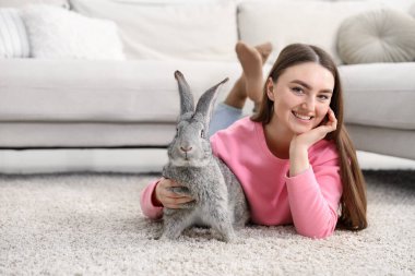 Evde yerde sevimli tavşanlı bir kadın var. Metin için boşluk