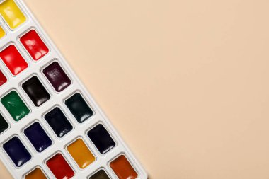 Bej arka planda suluboya palet, üst görünüm. Metin için boşluk