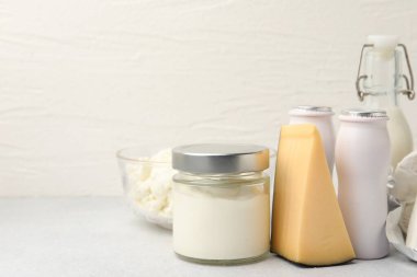 Açık gri masada farklı süt ürünleri, yakın çekim. Metin için boşluk