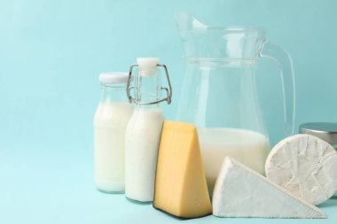 Açık mavi arka planda farklı süt ürünleri, yakın plan. Metin için boşluk