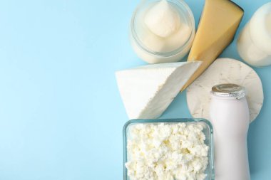 Açık mavi arka planda farklı süt ürünleri, düz yatak. Metin için boşluk