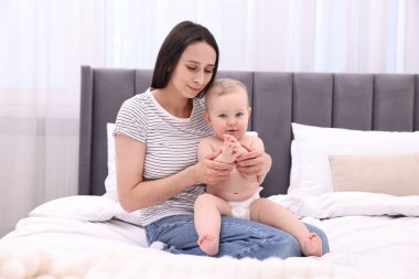 Anne, evde yatağında sevimli küçük bebeğiyle.