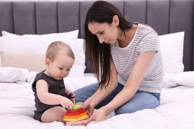 Anne, tatlı küçük bebeği ve evde yatağında oyuncağıyla