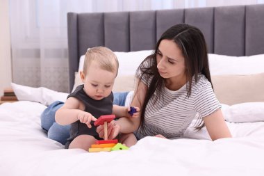 Anne, tatlı küçük bebeği ve evde yatağında oyuncağıyla