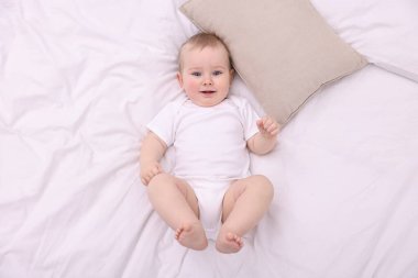 Evdeki yatakta uzanmış şirin küçük bebek, üst manzara.