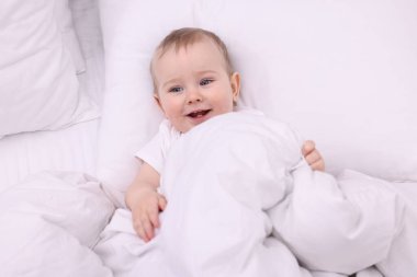 Evdeki yatakta uzanmış şirin küçük bebek, üst manzara.