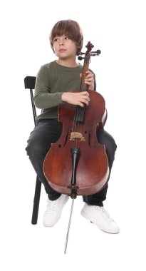 Küçük çocuk beyaz arka planda sandalyede keman çalıyor.