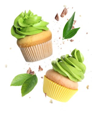 Beyaz arka planda yeşil kremalı lezzetli kekler uçuşuyor.