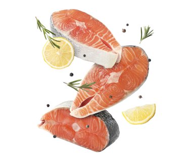 Beyaz arka planda biberiye ve limonlu taze somon bifteği