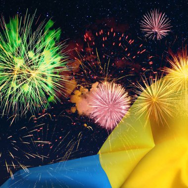 Ukrayna bayrağı ve gece gökyüzünde parlak havai fişekler. Ulusal bayram kutlaması