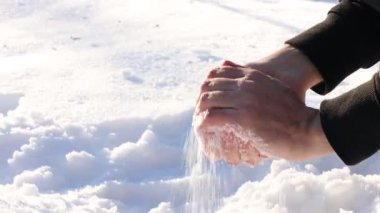 Sabahları kartopu yapan adam, yakın plan. Kamera yukarı hareket ediyor