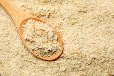 Arka plan olarak kuru maya taneleri ve kaşık, üst manzara. Metin için boşluk