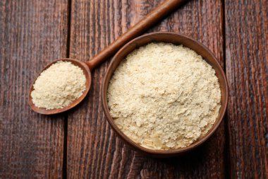 Kuru maya taneleri kasede ve kaşıklar ahşap masada, üst manzara