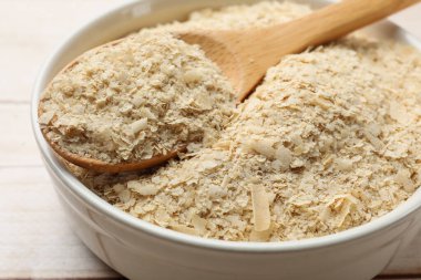 Kuru maya taneleri kasede ve kaşık tahta masada, yakın plan.