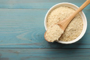 Kasede kuru maya taneleri ve açık mavi ahşap masada kaşık, üst manzara. Metin için boşluk