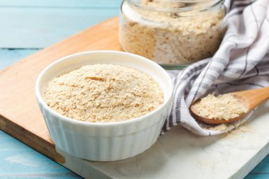 Kavanozda kuru maya, kaşık ve cam kavanoz açık mavi ahşap masa, yakın plan