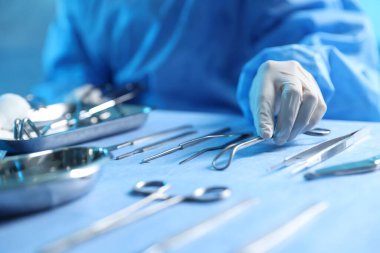 Hastanedeki masada farklı cerrahi aletleri olan doktor, yakın plan.