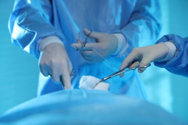 Tıbbi aletleri olan profesyonel cerrahlar ameliyathanede ameliyat yapıyorlar.