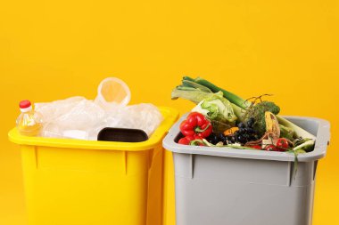 Çöp tenekeleri turuncu arka planda, yakın plan. Atık sıralama