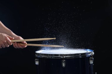 Siyah arkaplanda davul çalan bagetli adam, yakın plan