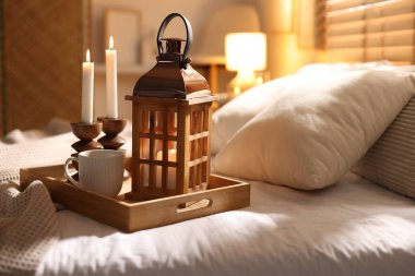 Güzel bir Noel feneri, yanan mumlar ve sıcak bir bardak içecekle birlikte.