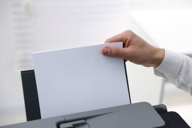 Kağıdı yazıcıya yükleyen adam arka planda bulanık, yakın plan. Metin için boşluk