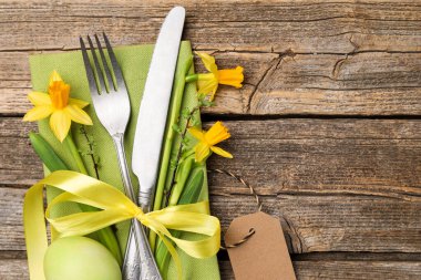 Paskalya sofrası. Güzel gümüş çatal bıçak dekoru ve ahşap arka planda boyanmış yumurta, üst manzara. Metin için boşluk