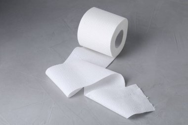 Gri masadaki tuvalet kağıdı rulosu, yakın plan.