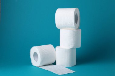 Açık mavi arkaplanda tuvalet kağıdı ruloları