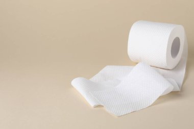 Bej arka planda tuvalet kağıdı rulosu, yakın plan. Metin için boşluk