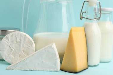 Açık mavi arka planda farklı süt ürünleri, yakın plan