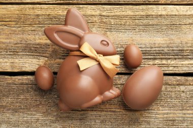 Çikolatalı Paskalya tavşanı ve yumurtalar ahşap masada, düz yatıyordu.