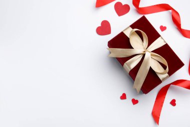 Sevgililer Günü. Güzel bir hediye, dekoratif kalpler ve beyaz arka planda kurdele, düz yatış. Metin için boşluk
