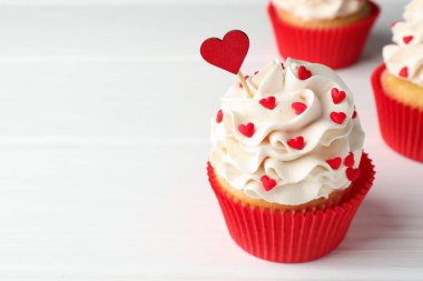 Sevgililer Günün kutlu olsun. Beyaz ahşap masadaki kalplerin şekline bürünmüş, serpiştirilmiş lezzetli kekler, yakın plan. Metin için boşluk